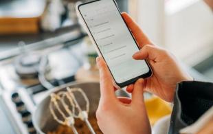 Verificando o telefone na cozinha